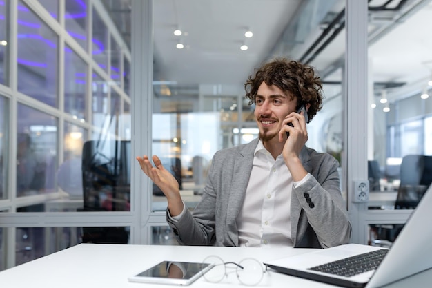 Successful successful businessman talking cheerfully in office on phone hispanic financier working