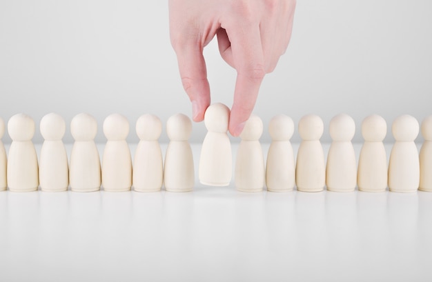 Successful team leader. Businessman hand choose people standing out from the crowd.