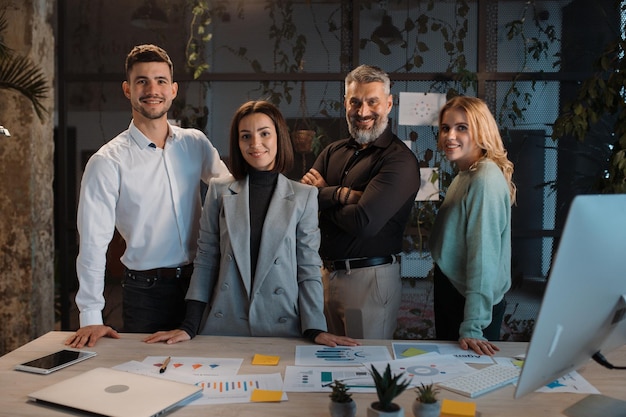 Successful team of men and women looking at camera confidently and posing in office diverse