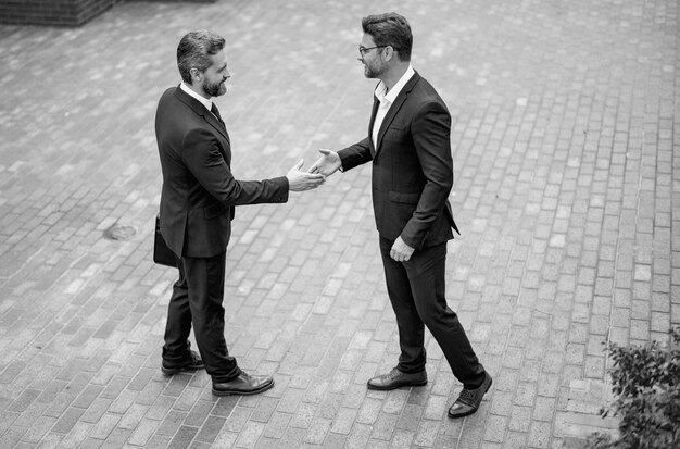 Successful teamwork business people shaking hands two businessmen shaking hands outdoors shaking