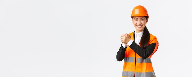 Successful winning female asian architect shaking hands together achieve goal Chief construction manager celebrating victory finish of building works standing white background delighted