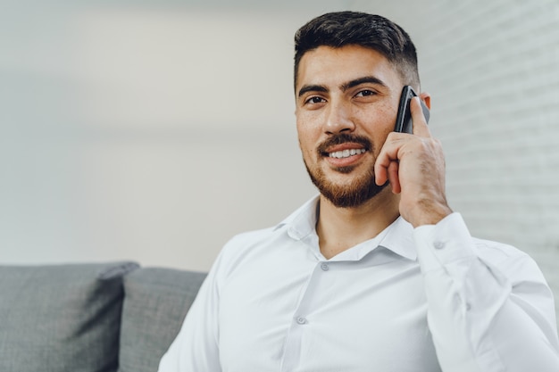 Successful young businessman talking on his cellphone, portrait