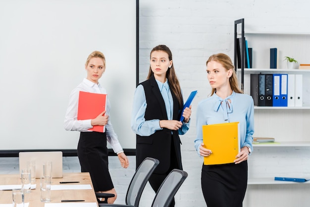 successful young businesswomen with folders of documents at modern office