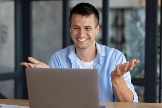 Successful young caucasian manager man using laptop for video communication with employees. Video conferencing or online education concept