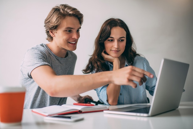 Successful young male and female students in casual apparel discussing funny information