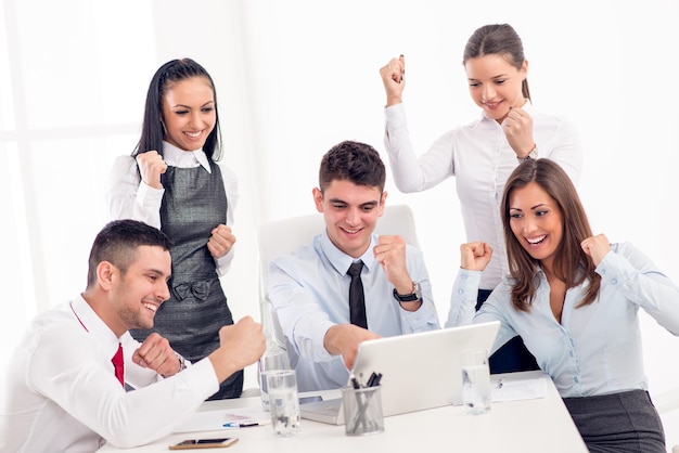 Successful young smiling colleagues working at laptop in the office.