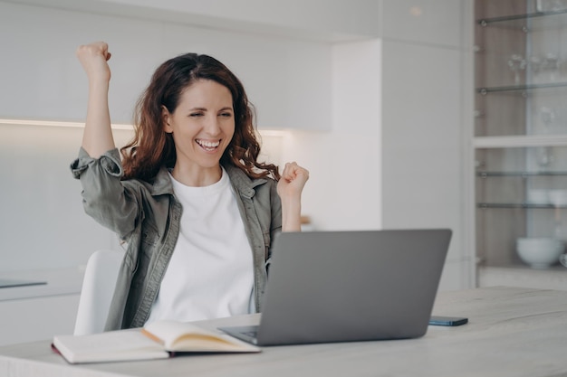 Successful young spanish woman has video call on computer Excited girl has internet conference