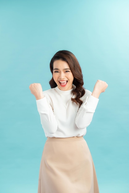 Successful young woman raising hands