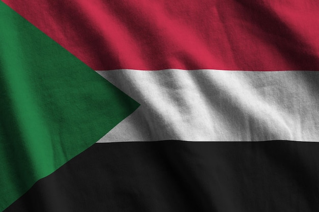 Sudan flag with big folds waving close up under the studio light indoors the official symbols and co