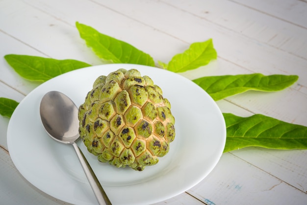 sugar apple on a white plate with stainless steel spoon ready to be eaten