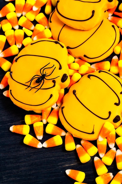 Sugar cookies with orange icing shaped like a pumpkin.