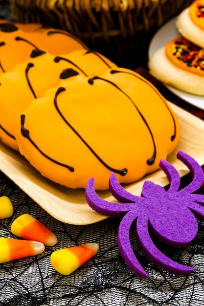 Sugar cookies with orange icing shaped like a pumpkin.