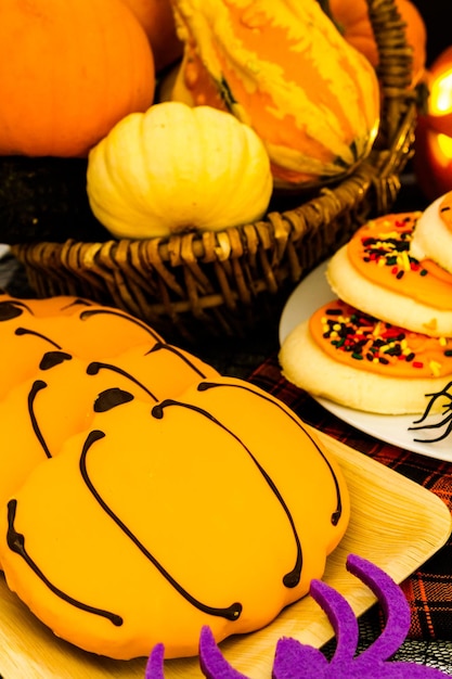 Sugar cookies with orange icing shaped like a pumpkin.