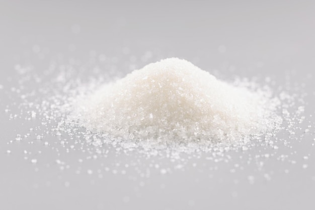 Sugar crystals pile on grey background heap of sweet powder sugar substitute