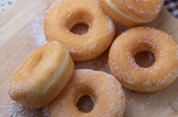 Sugar donuts on wooden board