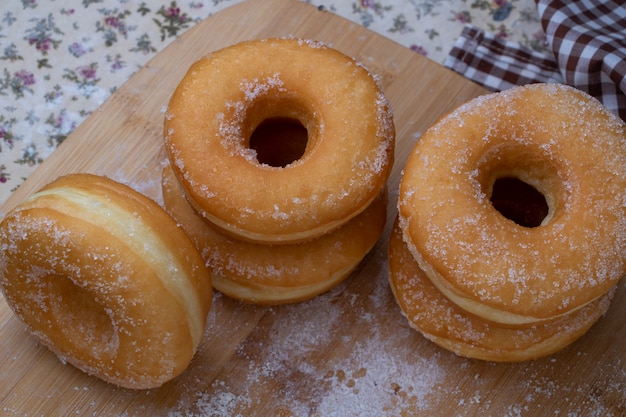 Sugar donuts on wooden board