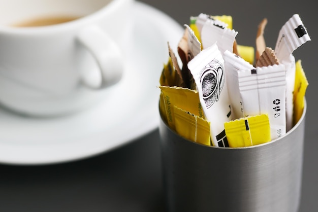 Sugar Substitute sweetener packet and tea cup on white background