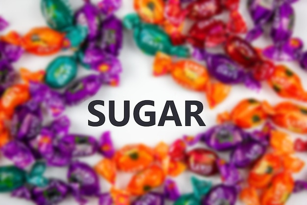 SUGAR word on the background of sweets with blurSymbol SUGAR on the background of lollipopssweets