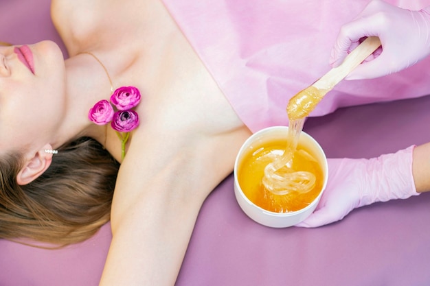 Sugaring epilation with liquate sugar at armpit