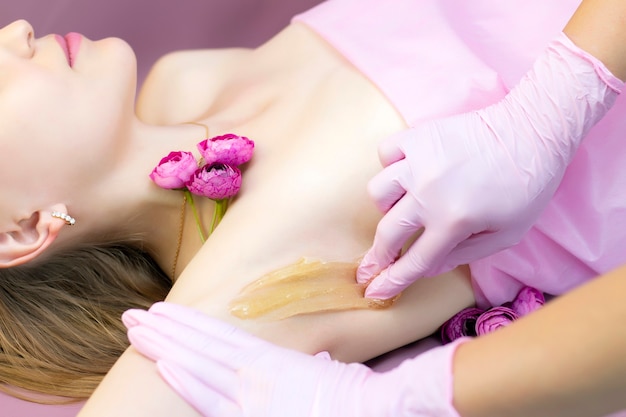 Sugaring epilation with liquate sugar at armpit