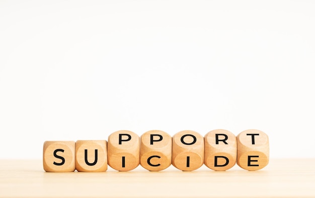 Suicide support concept. Flipping wooden blocks with words on table. Copy space