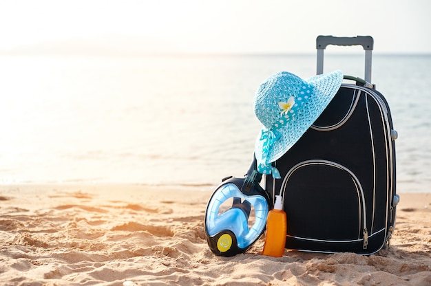 Suitcase and hat, sunscreen with a mask. 