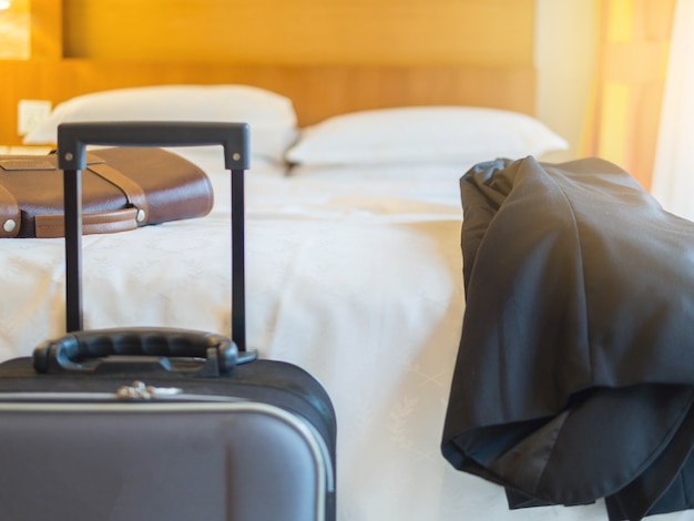 Suitcase in hotel room black suit and bag on the bed