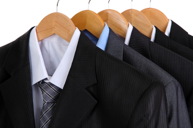 Suits with shirts on hangers on white background