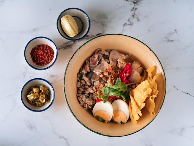 Suko Thai Pork Noodles in a dish isolated on mat top view on grey marble background