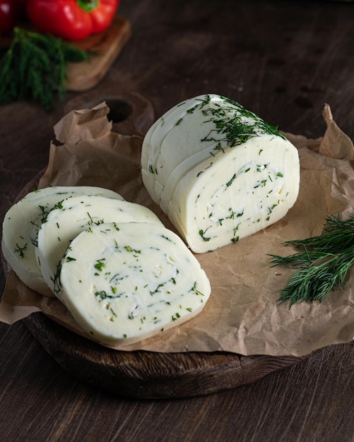 Suluguni cheese wuth dill on a wooden cutting board Vertical Selective focus