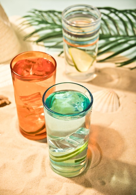 Summer alcoholic cocktails in colorful glasses on beach with white sand Summer sea ocean vacation and travel concept