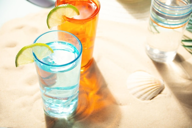 Summer alcoholic cocktails in colorful glasses on beach with white sand Summer sea ocean vacation and travel concept