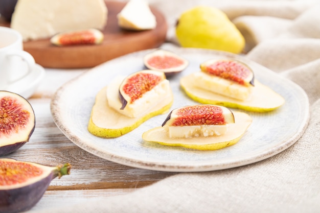 Summer appetizer with pear, cottage cheese, figs and honey   and linen textile.