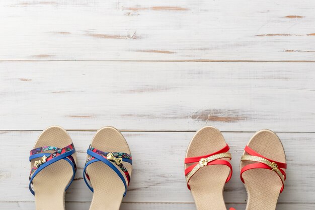 Summer background concept female sandals on light wooden surface