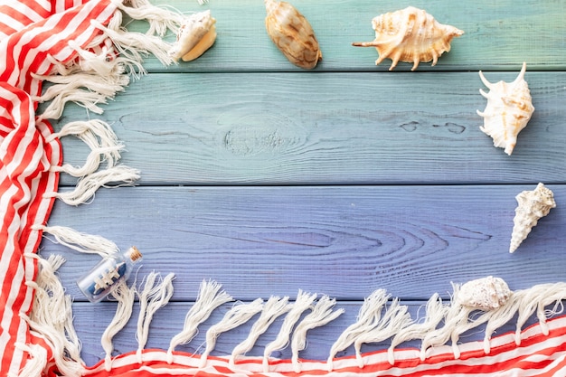 Summer background fringed pareos, seashells, on a blue wooden background