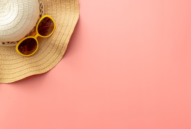 Summer background of starfish, straw hat, sunglasses on pink background