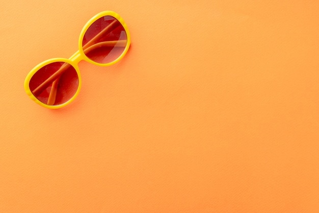 Summer background sunglasses on orange background