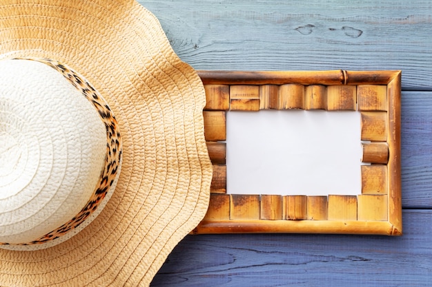 Summer background sunglasses, straw hat on a blue wooden background