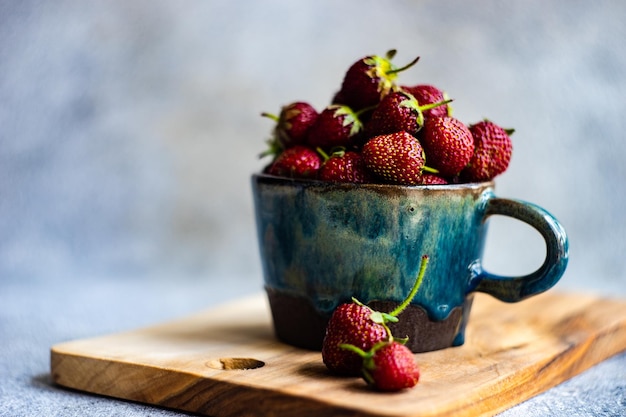 Summer background with ripe strawberries on concrete background