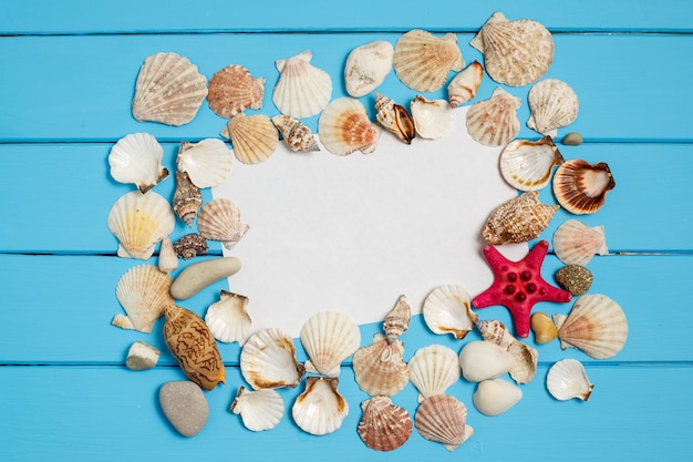 Summer background with the seashells and a blank note