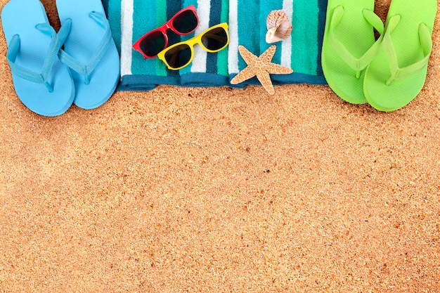 Summer beach background border, flip flops, sand copy space