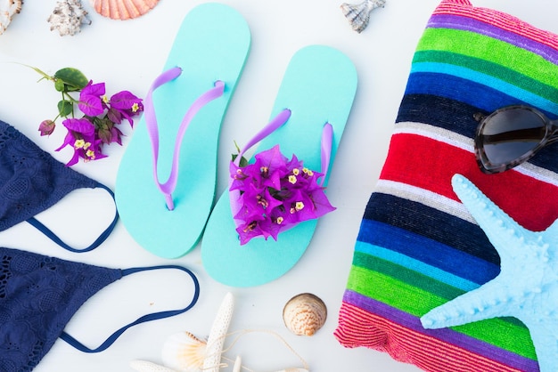 Summer beach fun sandals with swimming suit beach towel and starfish