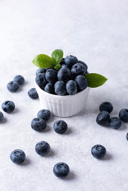 Summer berries, ripe blueberries in a bowl on a white background, healthy food.