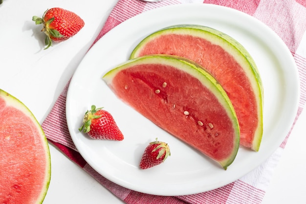 Summer berries watermelon slices and strawberries on a platter on a white table