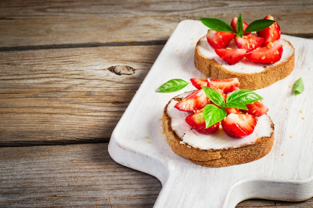 Summer breakfast bruschetta with strawberries, basil and cottage