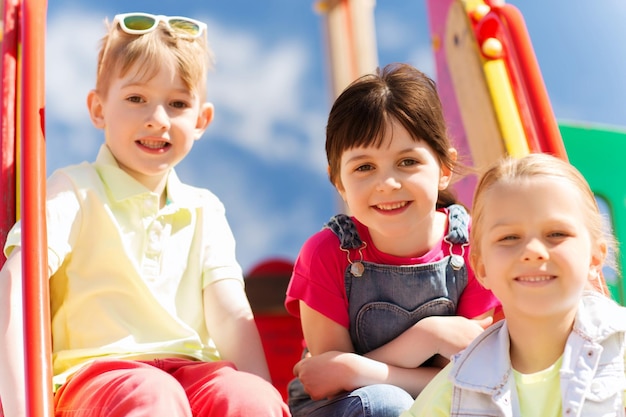 summer, childhood, leisure, friendship and people concept - group of happy kids on children playground