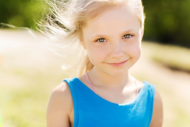 summer, childhood, leisure and people concept - happy little girl outdoors