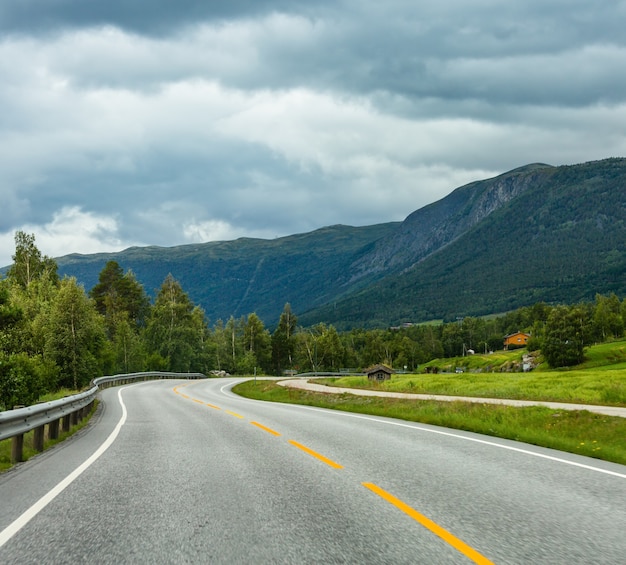 Summer cloudy mountain landscape with serpentine secondary road, Norway