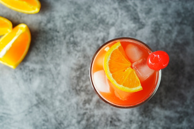 Summer cocktail. Orange juice with mint, syrop, fruit slices and cherry with ice.