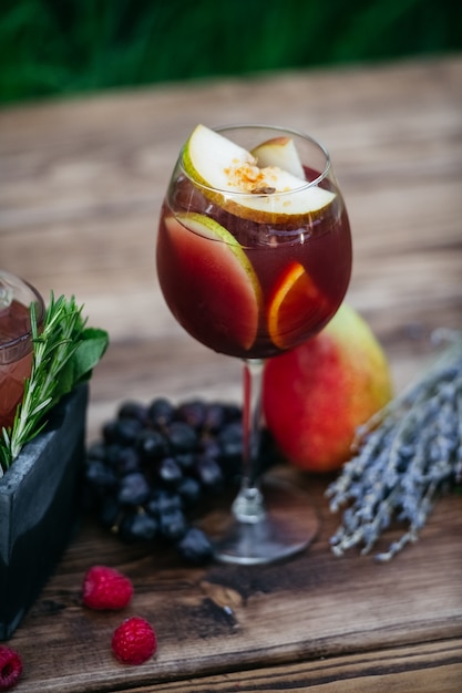 Summer cocktail with fruits on wooden table